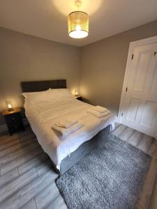 a bedroom with a large white bed with a rug at Teresa's Cottage in Kilcolgan