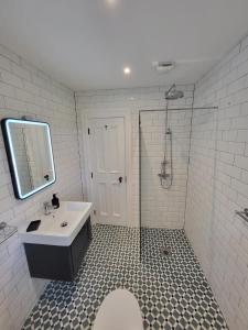 a white bathroom with a sink and a shower at Teresa's Cottage in Kilcolgan