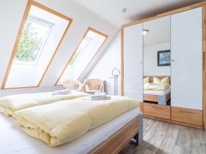 a bedroom with two beds and a mirror at Residenz "Zu den 3 Tannen" 5 in Zingst