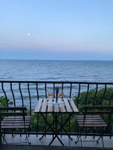 a wooden table with two wine glasses on a balcony at Apartment in a beach house Old town Nessebar in Nesebar