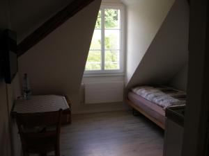 ein kleines Dachzimmer mit einem Fenster und einem Tisch in der Unterkunft Gasthof Rössli in Wyssachen