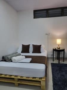 a bedroom with a large bed with a table and a lamp at EcoStudio in San José