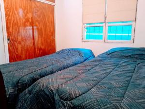 1 dormitorio con 2 camas y ventana en Departamento Barrio Bombal en Godoy Cruz