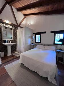 1 dormitorio con 1 cama blanca grande y lavamanos en El Bosque de Candeleda, en Candeleda