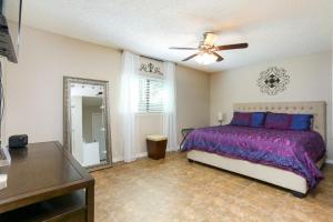 een slaapkamer met een bed en een plafondventilator bij Home with pool near Sea World & Lackland in San Antonio