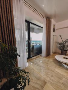 un soggiorno con una grande finestra e un tavolo di Sea view Apartment a Mamaia