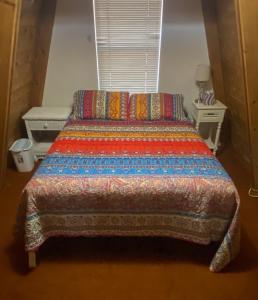 een bed met een kleurrijk dekbed in een slaapkamer bij Rustic Cabin 1 - Three Bedroom in Forest Lakes Estates