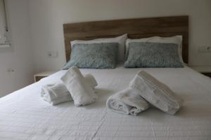 ein weißes Bett mit Handtüchern und Kissen darauf in der Unterkunft Casal Do Crego in O Grove