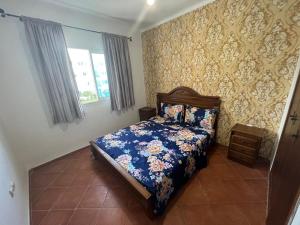 Un bel appartement à Jawhara Smir, Marina Smir في مارينا سمير: غرفة نوم مع سرير مع لحاف أزرق