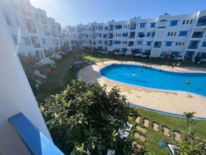 - une vue aérienne sur une piscine en face d'un bâtiment dans l'établissement Un bel appartement à Jawhara Smir, Marina Smir, à Marina Smir
