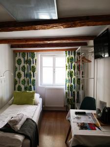 Zimmer mit einem Bett, einem Tisch und einem Fenster in der Unterkunft Cityhotel Junger Fuchs in Salzburg