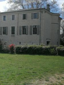 - un grand bâtiment en briques avec une cour devant dans l'établissement Le Clos de La Chardonnière, à Saulce-sur-Rhône