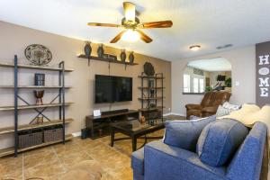 a living room with a blue couch and a tv at Home with pool near Sea World & Lackland in San Antonio