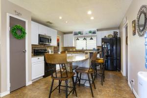 een keuken met witte kasten en een zwarte koelkast bij Home with pool near Sea World & Lackland in San Antonio