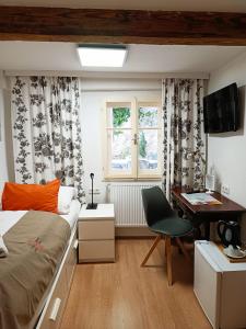 1 dormitorio con cama, escritorio y ventana en Cityhotel Junger Fuchs, en Salzburgo