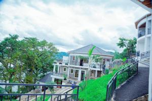 une maison sur une colline avec un balcon dans l'établissement KIGUFI HILL, Agape Resort & Kivu Edge, à Gisenyi