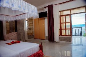 a bedroom with a bed and a large window at KIGUFI HILL, Agape Resort & Kivu Edge in Gisenyi