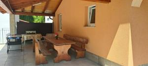 een veranda met een houten tafel en een bank op een huis bij Villa Tia, with jacuzzi, barbecue & green oasis in Opatija
