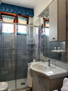 a bathroom with a sink and a glass shower at Furore house of Benedetta in Furore