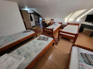 Zimmer mit 4 Betten und einem Klavier in der Unterkunft Betty Panzio in Miercurea Ciuc
