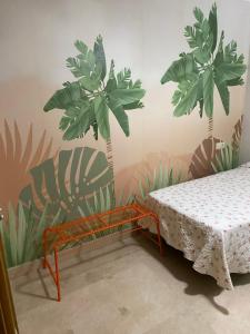 a room with a table and two palm trees on the wall at Apartamento Paseo Marítimo Antonio Banderas in Málaga