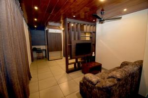 a living room with a couch and a flat screen tv at ARAKKAL GUESTHOUSE in Kalpetta