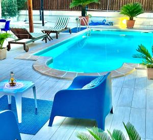 a swimming pool with chairs and a table next to it at Luena Home Luxury Apartment in Brusciano