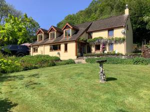 a house with a yard with a bird bath in the yard at Ty Twt - complete holiday home in Llandysul