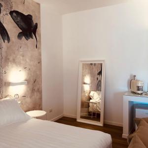 una camera d'albergo con letto e specchio di Il Borgo Boutique Rooms by KasaVacanze a Porto San Paolo