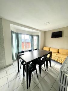 Antu Mahuida Apartments في سان كارلوس دي باريلوتشي: غرفة طعام مع طاولة وكراسي وأريكة