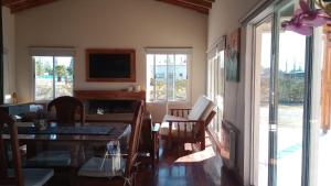 un soggiorno con tavolo, sedie e TV di Los Moros Country a San Rafael