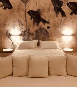 a bedroom with a bed with fish on the wall at Il Borgo Boutique Rooms by KasaVacanze in Porto San Paolo