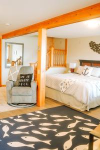 a bedroom with a bed and a chair at The Water's Edge Inn & Gallery in Baddeck