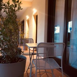 tavolo e sedie in una stanza con una pianta di Il Borgo Boutique Rooms by KasaVacanze a Porto San Paolo