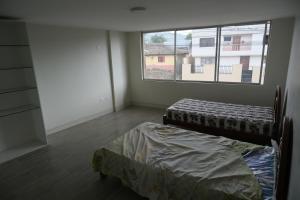 1 dormitorio con 2 camas y ventana grande en Paraíso San Marcos, en San Miguel de Salcedo