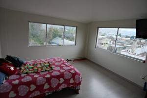 1 dormitorio con 1 cama y 2 ventanas en Paraíso San Marcos, en San Miguel de Salcedo