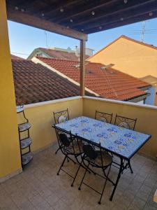 eine Terrasse mit einem Tisch und Stühlen auf dem Balkon in der Unterkunft Appartamento Rosy in Rimini