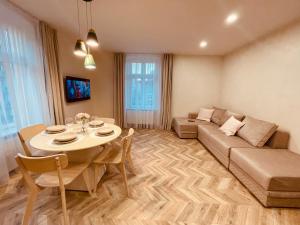 una sala de estar con un sofá y una mesa en KOBIELA APARTMENTS Family Delux KTW City Center, en Katowice