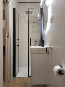 a white bathroom with a sink and a shower at Piso NUEVO en centro de Madrid in Madrid