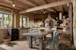 a large kitchen with a wooden table and chairs at Villa Kanaki 