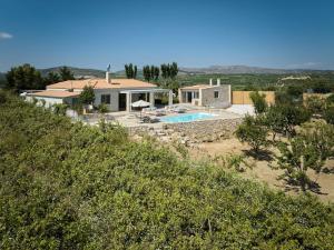 a house with a swimming pool on a hill at Villa Kanaki 