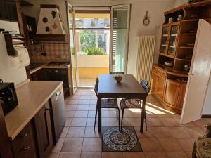 eine Küche mit einem Tisch, einem kleinen Tisch und Stühlen in der Unterkunft Appartamento Rosy in Rimini