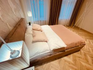 a bedroom with a bed and a table with a lamp at KOBIELA APARTMENTS Family Delux KTW City Center in Katowice