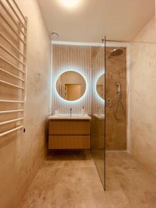 a bathroom with a shower and a mirror at KOBIELA APARTMENTS Family Delux KTW City Center in Katowice