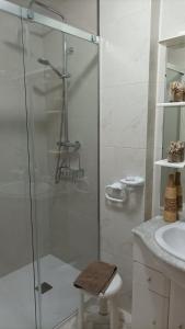 a bathroom with a glass shower and a sink at Apartamento A Atalaia in Laxe