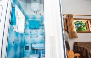 a blue tiled bathroom with a sink and a toilet at Tzatzaminia Cottage in Argostoli