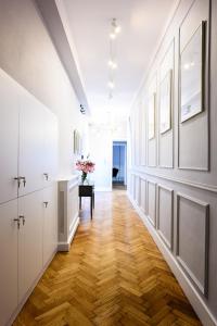 a hallway with white walls and wooden floors and a table at Wiślna Main Square Apartments in Krakow