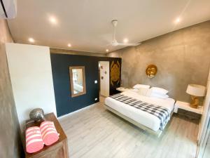1 dormitorio con 1 cama y 1 mesa con 2 zapatos rosas en Hostel-Island Paradise, Saboga Lodge and Villa Noelia en Panamá