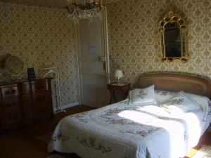 a bedroom with a bed and a dresser and a mirror at Lalobema in Machecoul