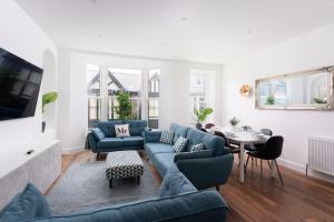 een woonkamer met blauwe banken en een tafel bij 3 Bed, sea views, central Penzance,newly renovated in Penzance